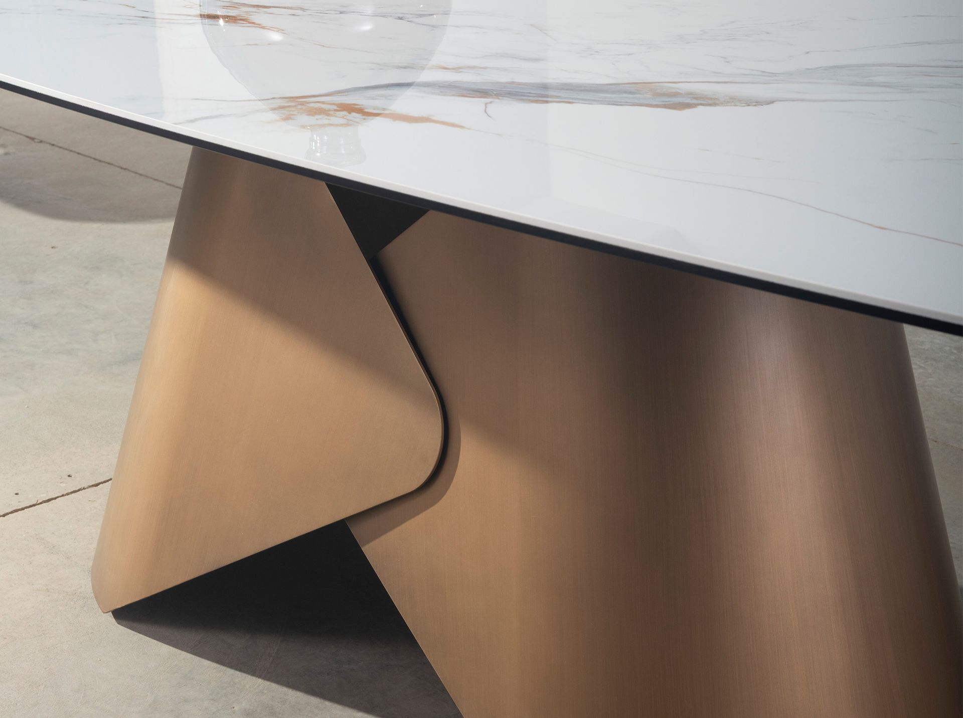 Oval dining table with porcelain marble barrel and bronze-coloured steel barrel